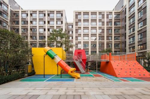 a playground in front of a building with a slide at AURAYA BY SUNING NANJING XUZHUANG in Nanjing
