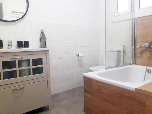 a bathroom with a tub and a sink and a mirror at Vacation house in the mountains in Esparraguera