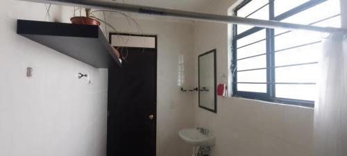 a bathroom with a black door and a sink at Departamento sencillo, ideal para descanso in Santa María del Tule