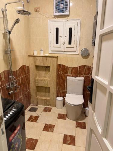 a small bathroom with a toilet and a shower at Mansoura sweet home hotel apartments in Mansoura