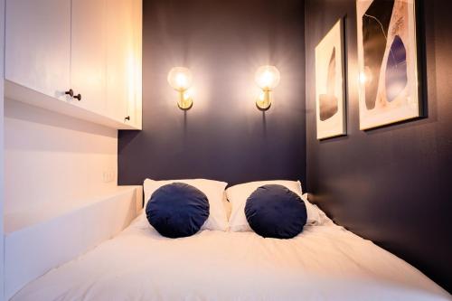 une chambre avec un lit avec deux oreillers dessus dans l'établissement OIQIA • Jadéa • Saphir, à Bressuire