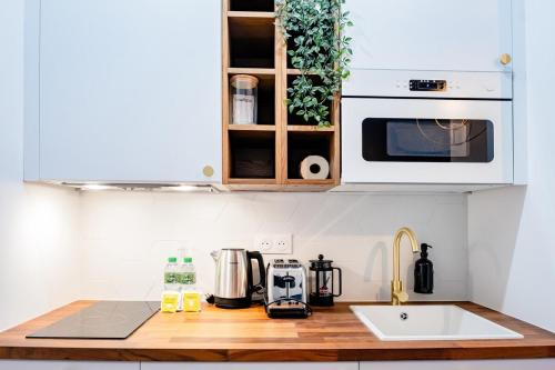 un comptoir de cuisine avec un évier et un micro-ondes dans l'établissement OIQIA • Jadéa • Saphir, à Bressuire