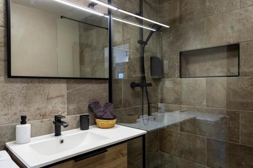 une salle de bain avec un lavabo et une douche avec un miroir dans l'établissement OIQIA • Clairière, à Bourges