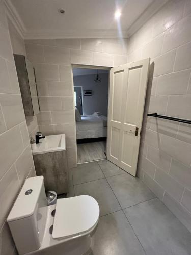 a white bathroom with a toilet and a sink at Familia in Pietermaritzburg