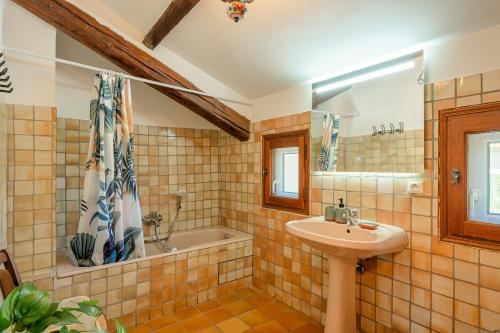 une salle de bain avec un lavabo et une baignoire dans l'établissement La Maison de Sophie, à Châteauneuf-de-Gadagne