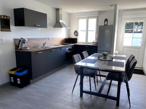 une cuisine avec une table et des chaises dans une cuisine dans l'établissement A la petite maison, à Wailly-Beaucamp
