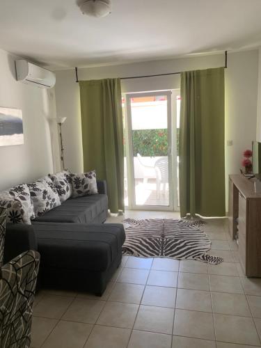 a living room with a couch and a window at Location Apartments in Herceg-Novi