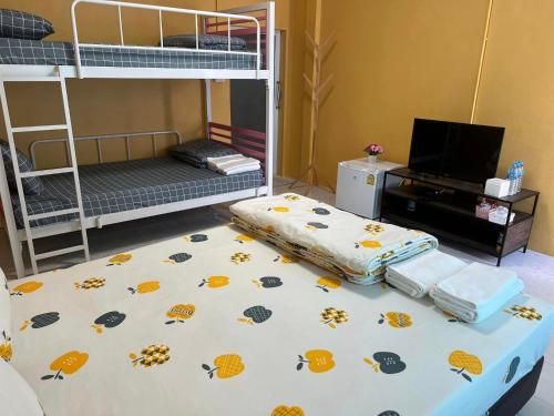 a room with two bunk beds and a television at vasita homestay satun in Ban Thung Nui