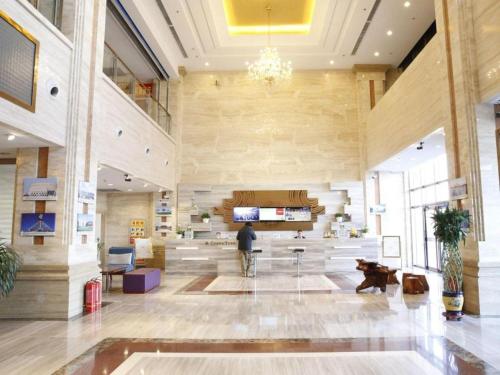 a lobby of a building with a person in the middle at GreenTree Inn Ordos Kangbashi District Ulan Mulun Street Branch in Ordos