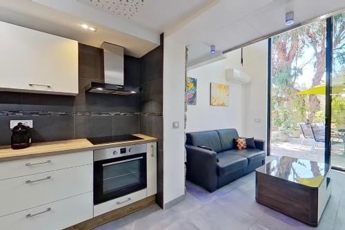 une cuisine et un salon avec un canapé et une table dans l'établissement VbyOnyx, à Olmeto