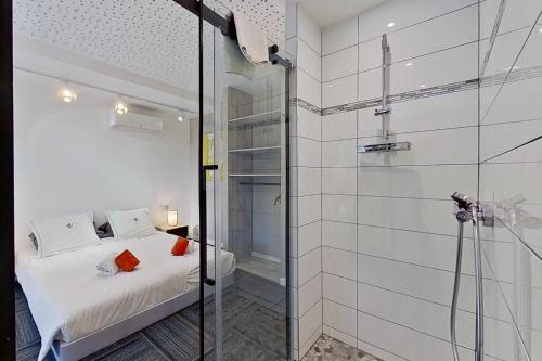 a bathroom with a bed and a glass shower at VbyOnyx in Olmeto