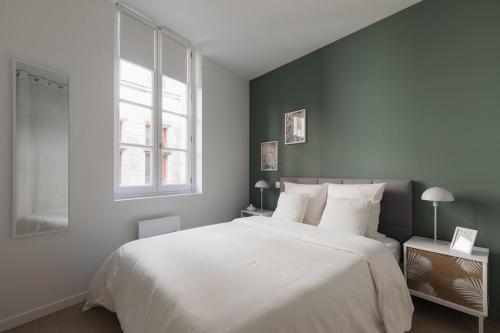 une chambre avec un grand lit blanc et une fenêtre dans l'établissement OIQIA • Arthéa • Esquisse, à Périgueux