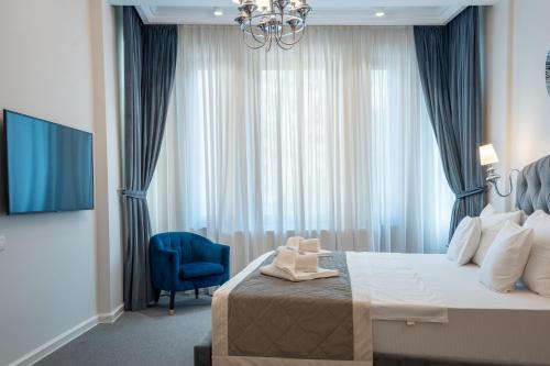 a hotel room with a bed and a blue chair at HIGHLINE DOWNTOWN ApartHotel OLDTOWN UNIRII SQUARE in Bucharest