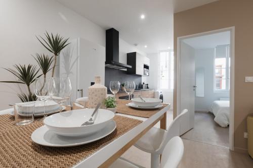 une salle à manger avec une table avec des assiettes et des verres à vin dans l'établissement OIQIA • Arthéa • Esquisse, à Périgueux