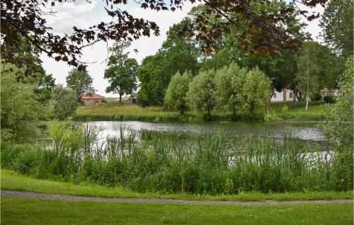 a pond in a park with grass and trees at 1 Bedroom Nice Home In Tomelilla in Tomelilla