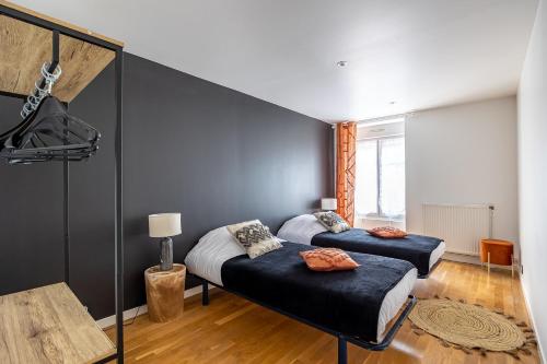 une chambre avec deux lits et un mur bleu dans l'établissement OIQIA • Téralis • Hivernal, à Annonay