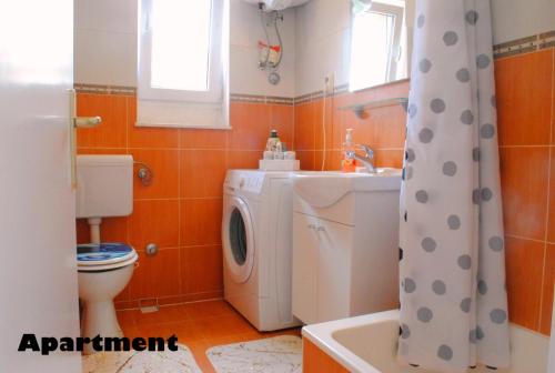 a bathroom with a washing machine and a washer at Sunshower apartment and studio in Split