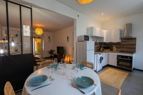 a kitchen and dining room with a white table and chairs at Le Globe Trotteur ~ Centre-ville ~ Terrasse in Thouars