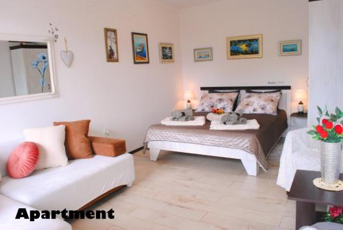 a bedroom with two beds and a white couch at Sunshower apartment and studio in Split