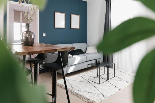 un salon avec un canapé, une table et des chaises dans l'établissement OIQIA • Arthéa • Graphiste, à Périgueux