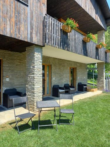 d'une terrasse avec 2 chaises et une table sur gazon. dans l'établissement RELEVEN GUEST HOUSE, à Vernante