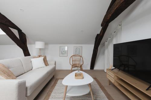 un salon avec un canapé blanc et une télévision dans l'établissement OIQIA • Arthéa • Atelier, à Périgueux