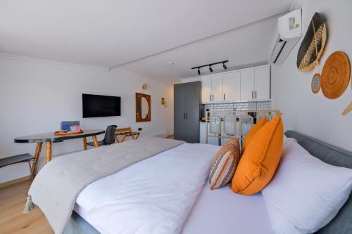 a bedroom with a large white bed with orange pillows at Körfez Residence in Fethiye