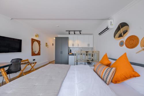 a bedroom with a large white bed with orange pillows at Körfez Residence in Fethiye