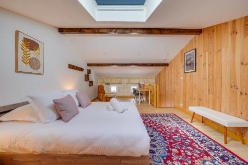 ein Schlafzimmer mit einem großen weißen Bett und Holzwänden in der Unterkunft La Riveraine - Belle maison à 20 min de Bordeaux in Lormont