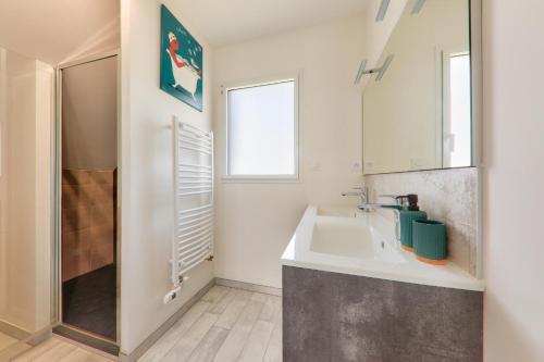 une salle de bain avec un lavabo et une douche dans l'établissement Maison avec jardin - à 400m plage des Govelins, à Saint-Gildas-de-Rhuys