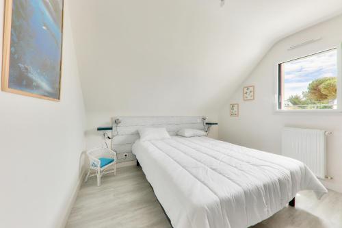 une chambre blanche avec un lit et une fenêtre dans l'établissement Maison avec jardin - à 400m plage des Govelins, à Saint-Gildas-de-Rhuys