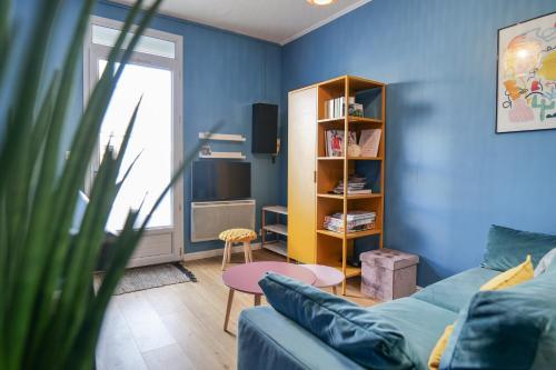 un salon bleu avec un canapé et une table dans l'établissement Appartement cosy en souplex Quartier Saint Michel Les Sables - 2 personnes, à Les Sables-dʼOlonne