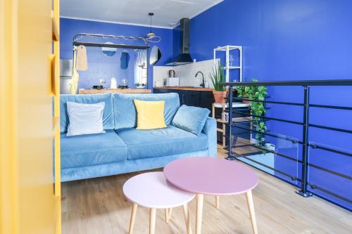 Una sala de estar azul con un sofá azul y dos mesas. en Appartement cosy en souplex Quartier Saint Michel Les Sables - 2 personnes, en Les Sables-dʼOlonne