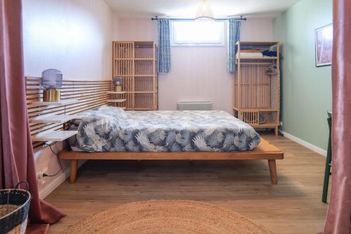 1 dormitorio con cama y estanterías de madera en Appartement cosy en souplex Quartier Saint Michel Les Sables - 2 personnes, en Les Sables-dʼOlonne