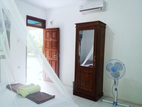 a room with a fan and a mirror and a door at Tangkoko Macaca in Rinondoran