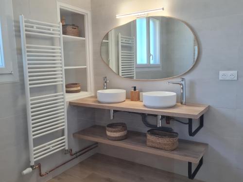 une salle de bain avec deux lavabos et un miroir dans l'établissement La maison ensoleillée, à Rivesaltes