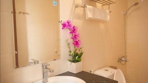 a bathroom with a sink and a vase of flowers at Hotel Thanh loi in Mỹ Ðuc