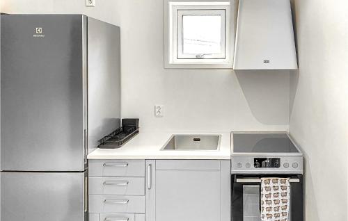 a kitchen with a stainless steel refrigerator and white cabinets at 2 Bedroom Cozy Home In Gotlands Tofta in Västergarn