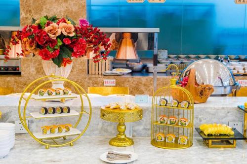 a table with a bunch of food and flowers at Junyu Grand Hotel Qinhuangdao in Qinhuangdao