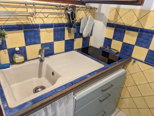 un évier dans une cuisine avec des carreaux bleus et jaunes dans l'établissement BELLE VUE sur MER au CALME, à Argelès-sur-Mer