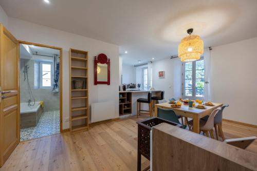 une cuisine et un salon avec une table et une salle à manger dans l'établissement Grande Anita - Centre ville - Parking privé, à Barcelonnette
