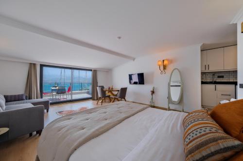 a large bedroom with a large bed and a living room at Körfez Residence in Fethiye