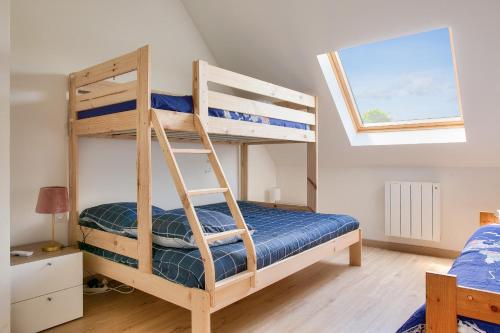 une chambre avec deux lits superposés et une fenêtre dans l'établissement Grande maison et beau jardin pour 8, à Clohars-Fouesnant