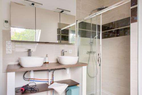 une salle de bain avec deux lavabos et une douche dans l'établissement Grande maison et beau jardin pour 8, à Clohars-Fouesnant