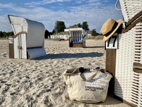 a bag and chairs on a sandy beach at Lagunenstadt am Haff Fewo 119 - Marina in Ueckermünde