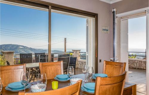 a dining room with a table and chairs and a large window at Gorgeous Home In Sant Cebrià De Vallalt in Sant Cebrià de Vallalta