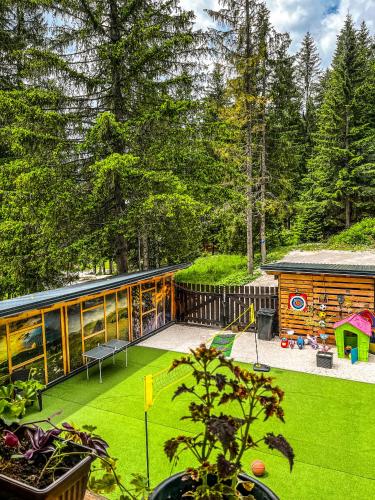 a backyard with a log cabin and green grass at Vila Bašić Vlašić Apartman VUK in Vlasic