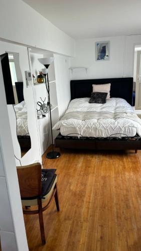 une chambre avec un lit et une chaise dedans dans l'établissement F2 aux porte de Paris - 4 pers, à Champigny-sur-Marne
