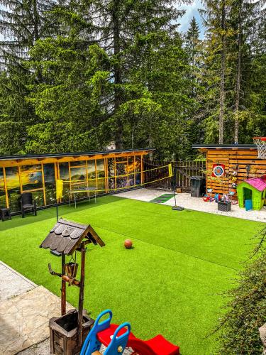 a backyard with a artificial lawn and a playground at Vila Bašić Vlašić Apartman MEDO in Vlasic