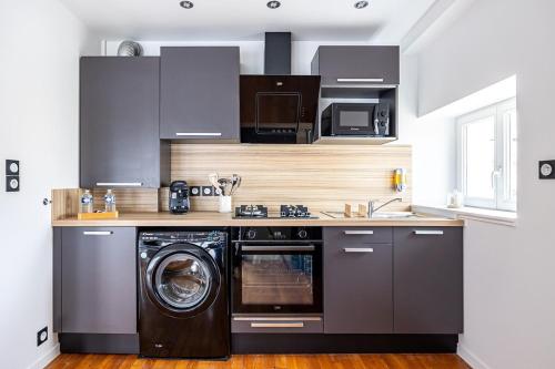 une cuisine avec un lave-linge et un lave-linge dans l'établissement OIQIA • Téralis • Équinoxe, à Annonay